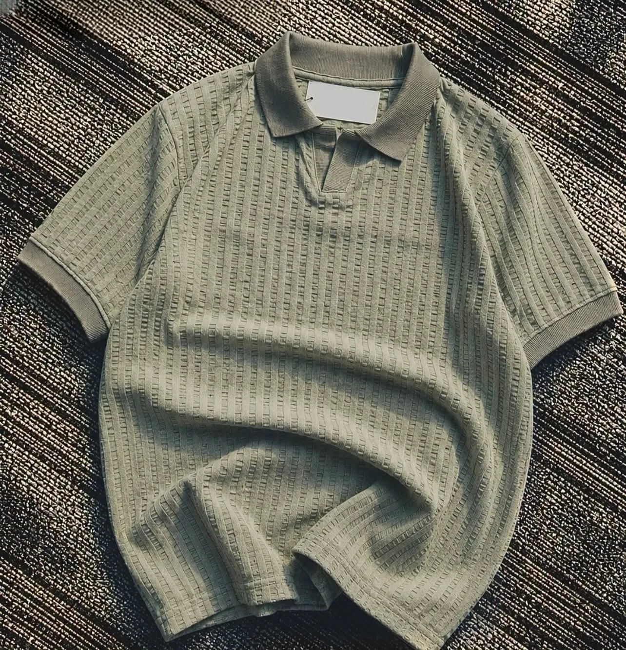 Textured green knit polo flat lay