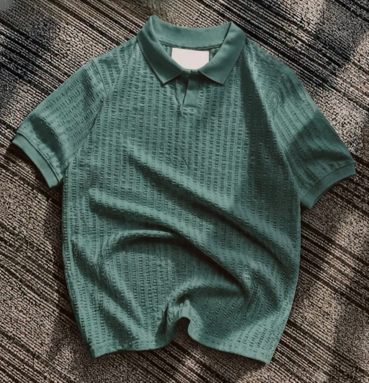 Textured teal knit polo flat lay