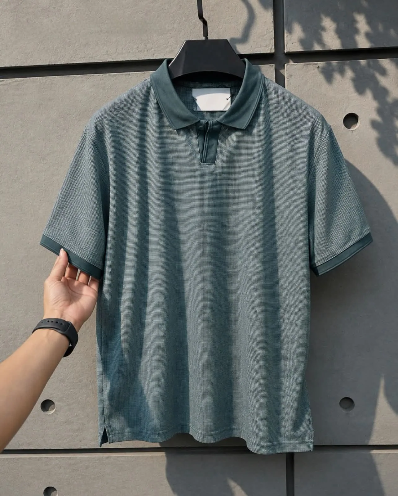 Textured teal knit polo on hanger