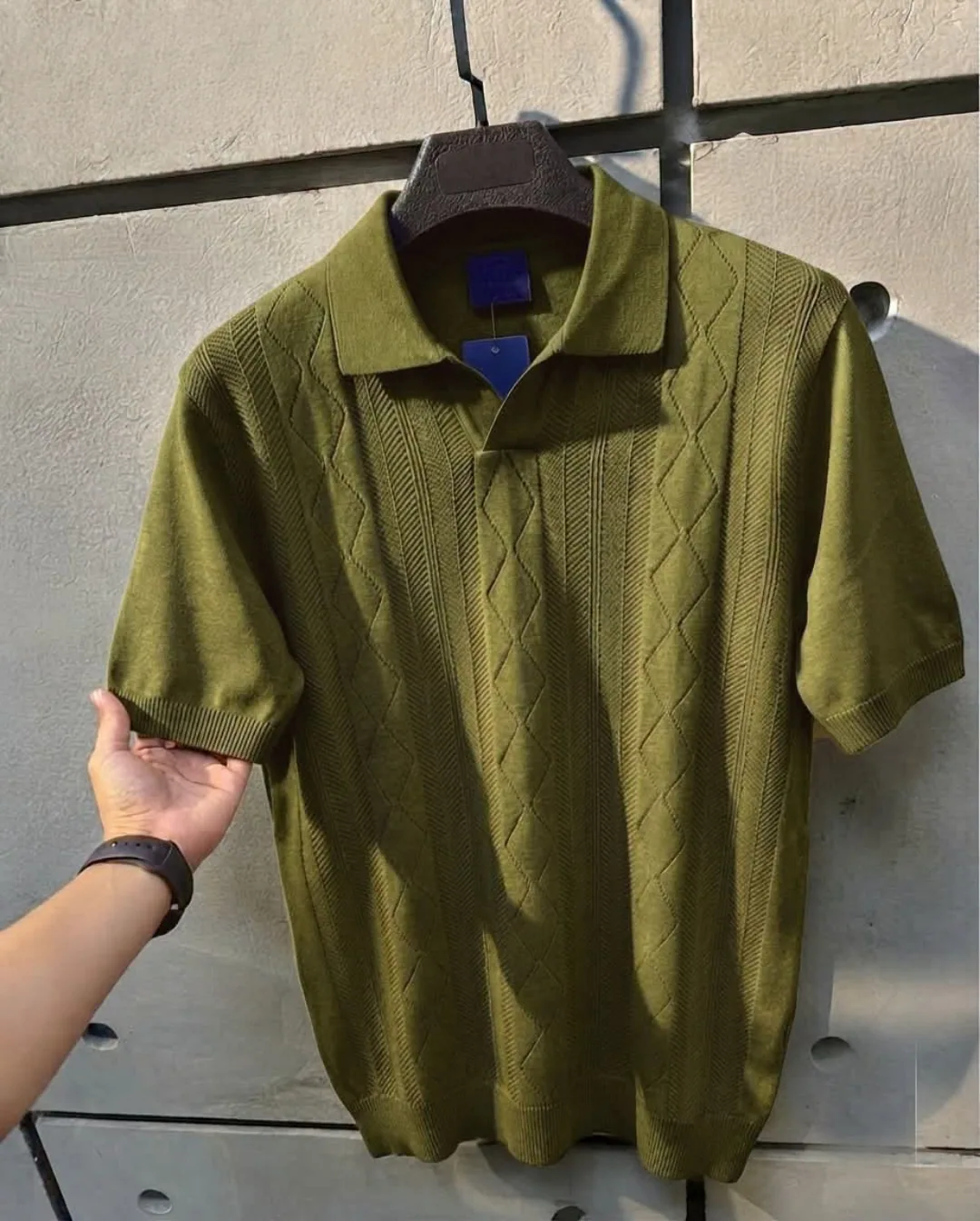 Olive cable-knit polo on hanger